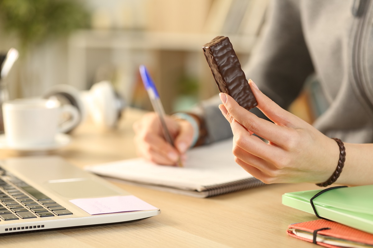 Close,Up,Of,Student,Girl,Hands,Holding,Chocolate,Snack,Bar