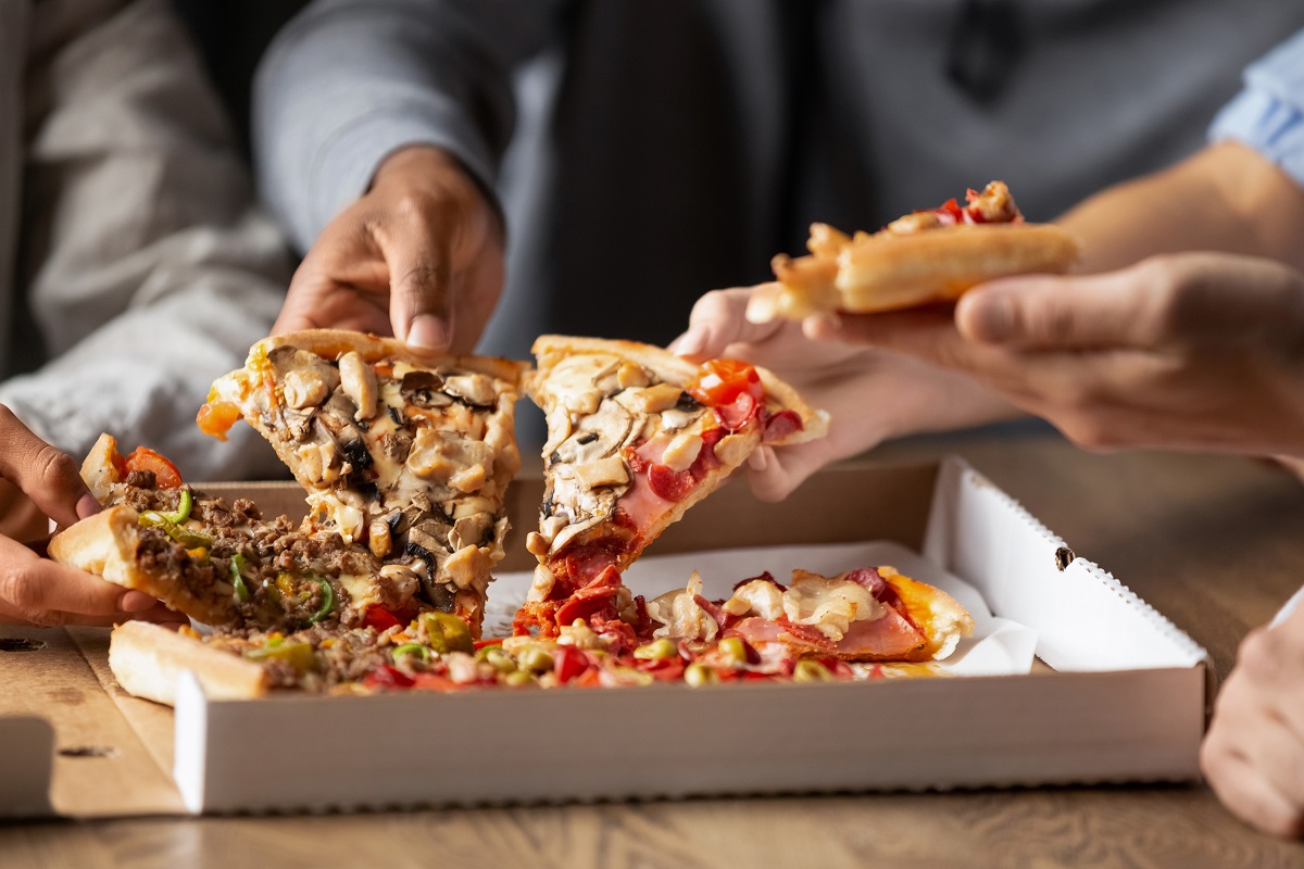 Close,Up,Of,Multiethnic,Young,People,Gather,In,Pizzeria,Together