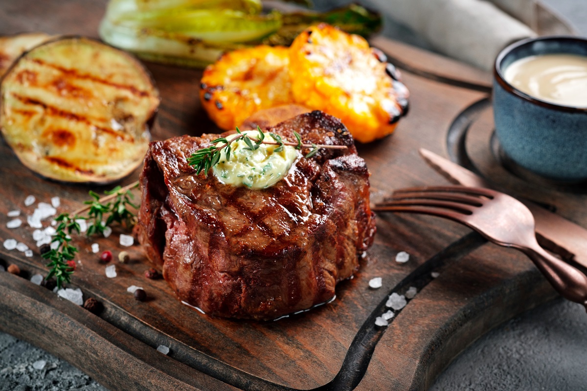 Grilled,Beef,Tenderloin,Steak,On,A,Wooden,Board,With,Butter