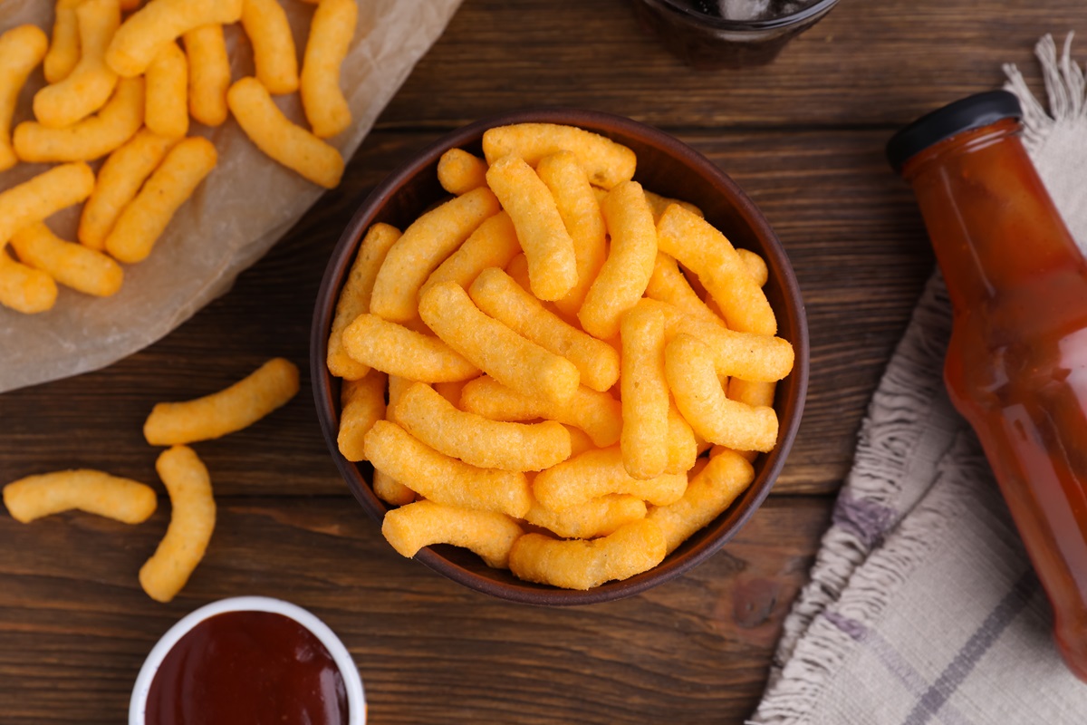 Crunchy,Cheesy,Corn,Snack,And,Ketchup,On,Wooden,Table,,Flat