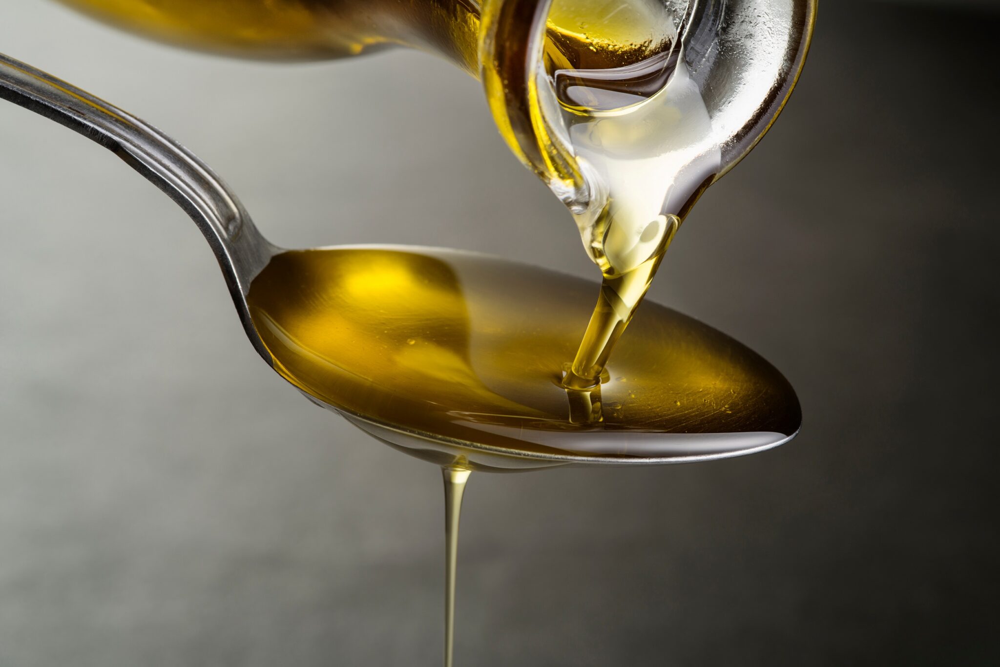 Oil,Pouring,And,Dripping,To,The,Spoon,Close,Up