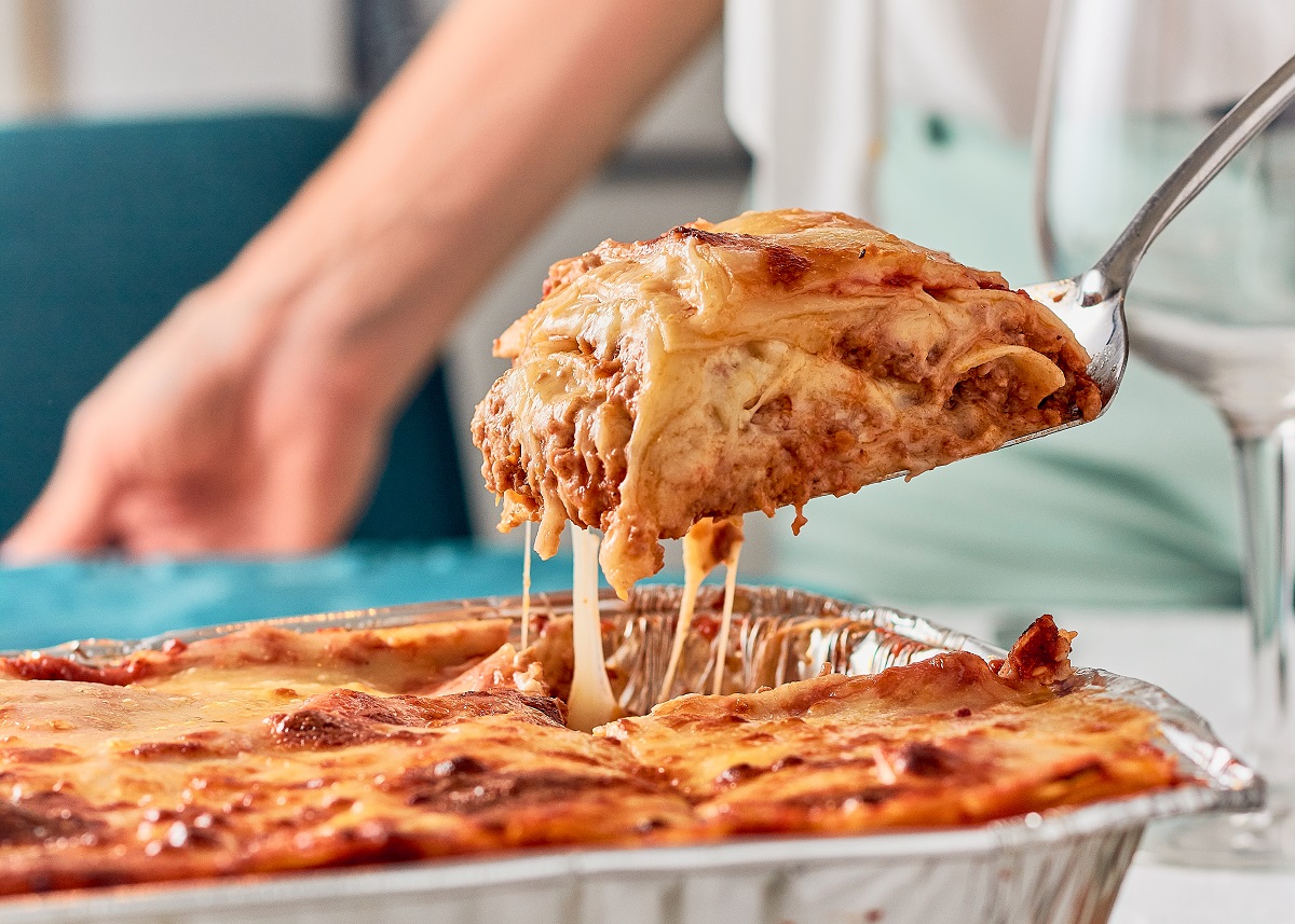 Woman,Serving,Portion,Of,Lasagna,Food