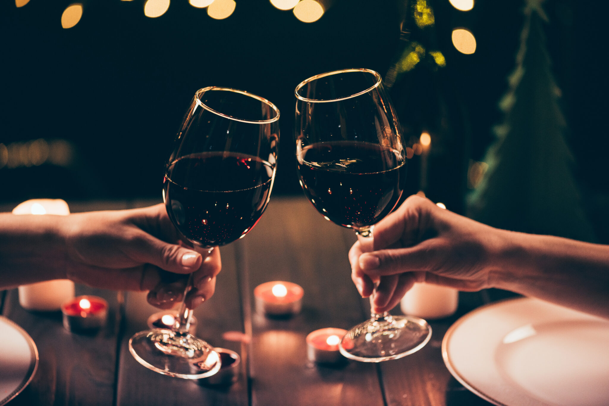 Cropped,Shot,Of,Two,Women,Clinking,Glasses,With,Wine,Over