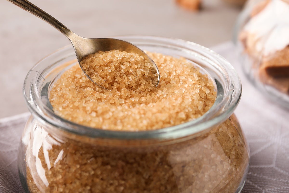 Taking,Spoon,Of,Brown,Sugar,From,Glass,Bowl,On,Table,