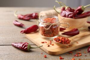 Chili,Pepper,Flakes,And,Pods,On,Wooden,Table