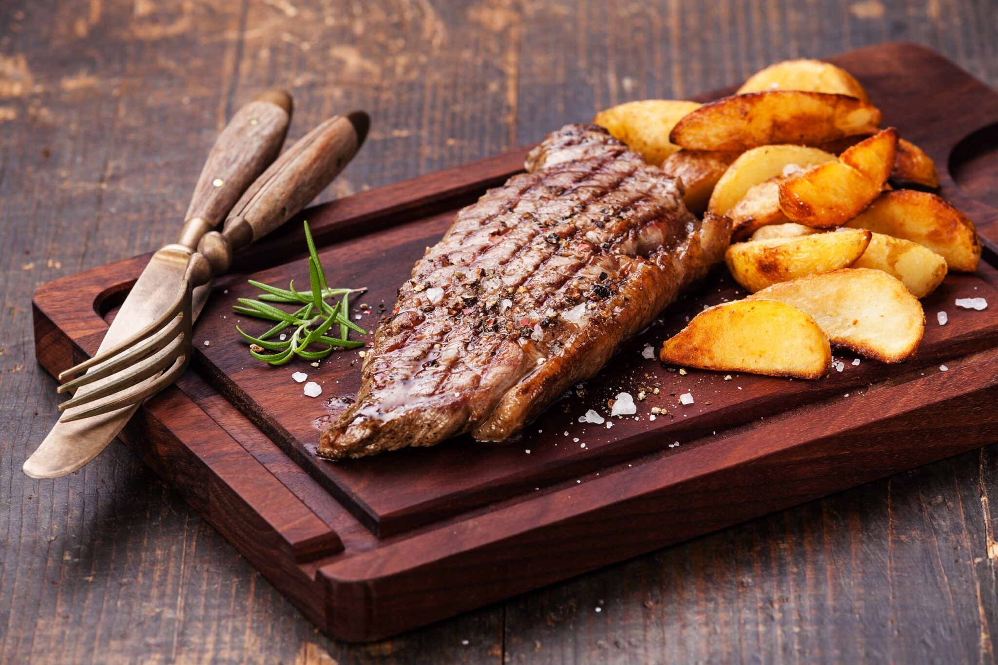 Well,Done,Grilled,New,York,Steak,With,Roasted,Potato,Wedges