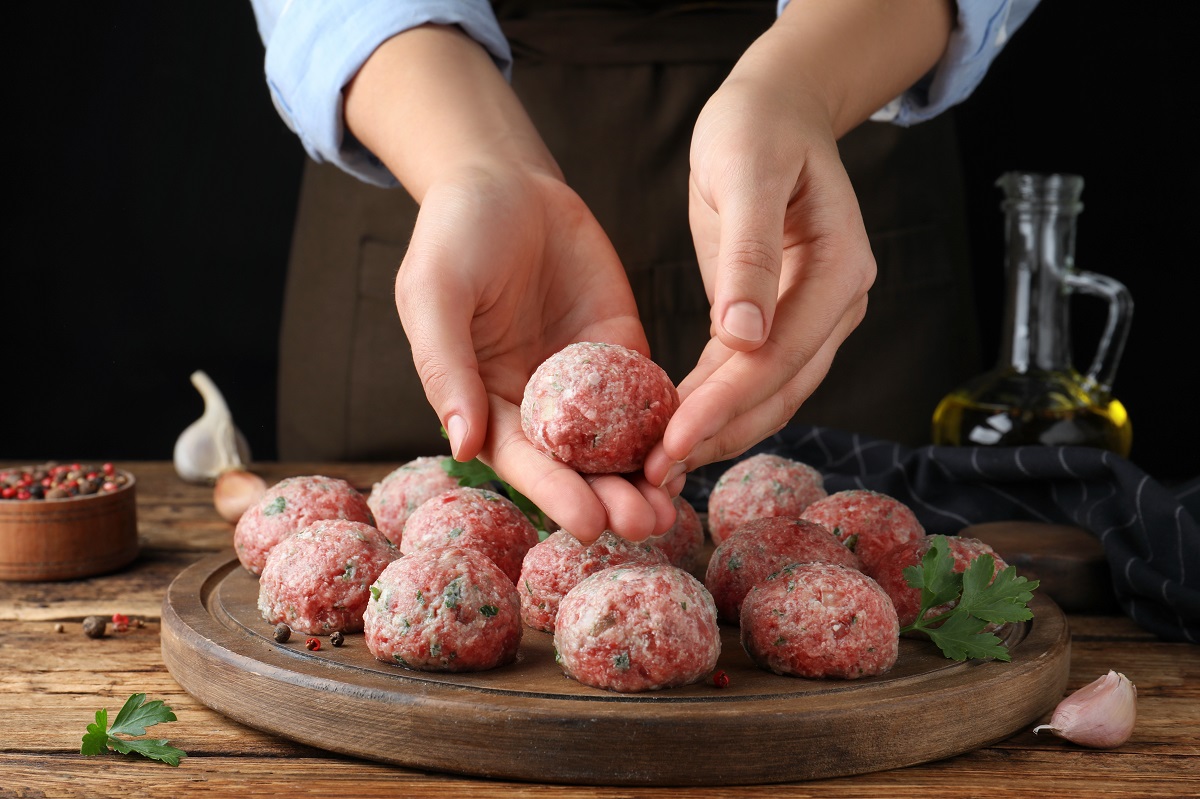 Woman,Making,Fresh,Raw,Meatballs,At,Wooden,Table,,Closeup