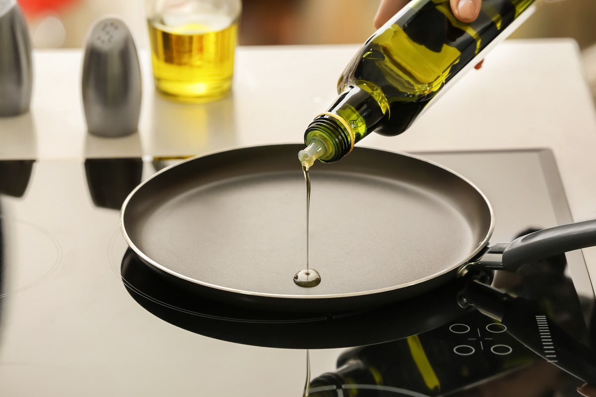 Pouring,Of,Olive,Oil,Onto,Frying,Pan,On,Stove
