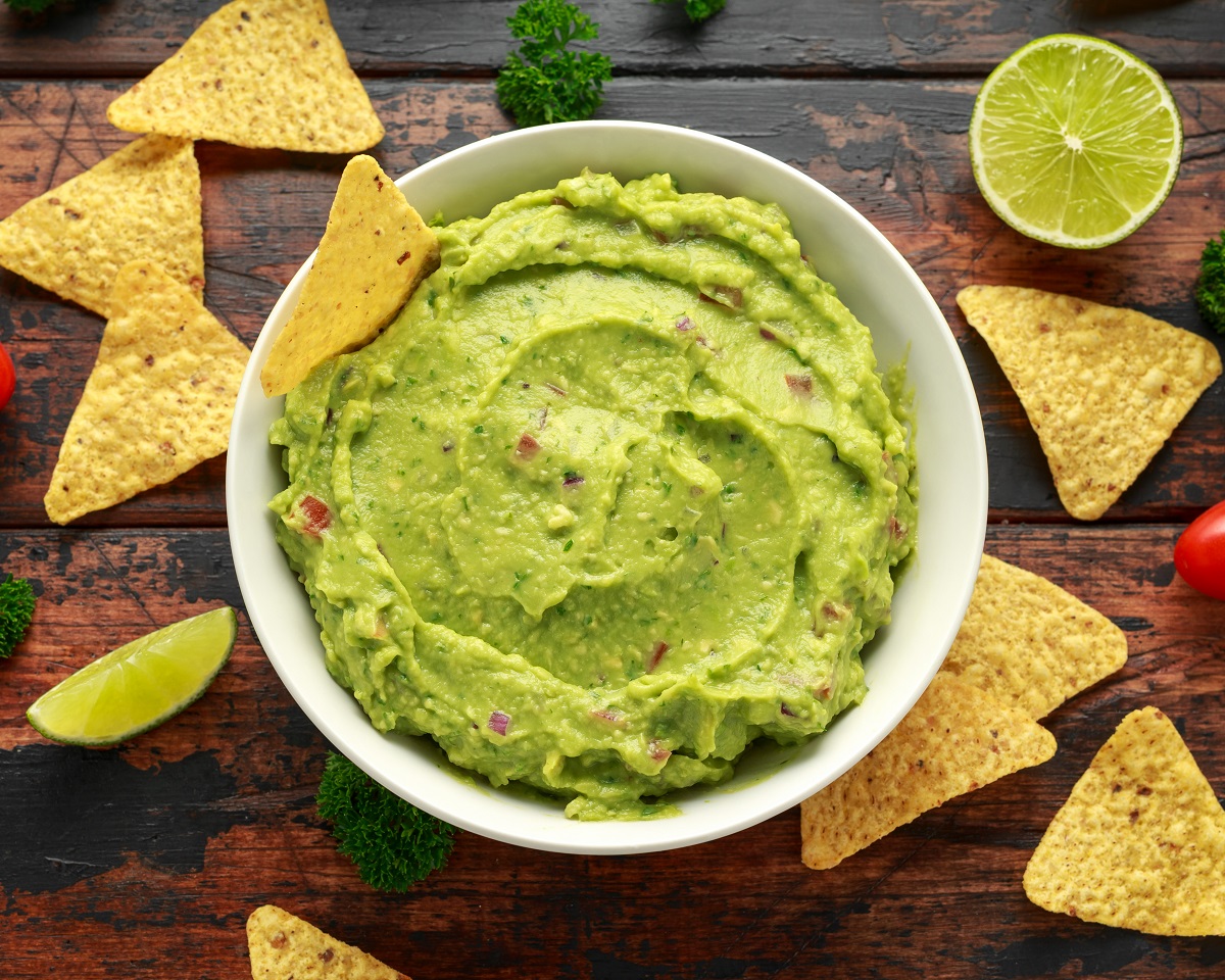 Bowl,Of,Fresh,Guacamole,With,Nachos,Chips,And,Herbs.,Healthy