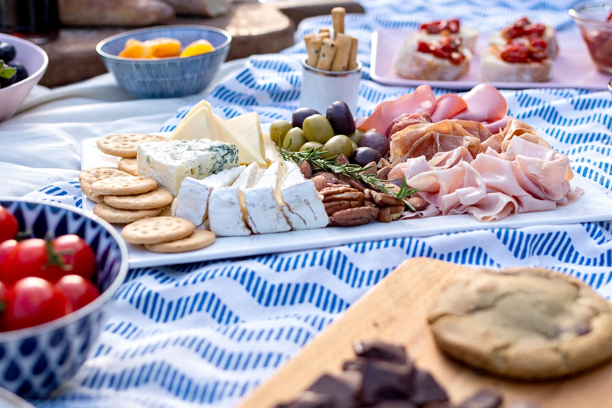 Romantic,Picnic,Setting,In,The,Garden,,Blue,Cloth,And,Pillows.