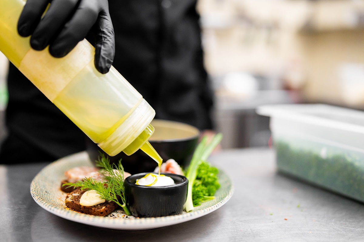 Chef,In,Black,Gloves,Drizzling,Green,Herb,Infused,Oil,From