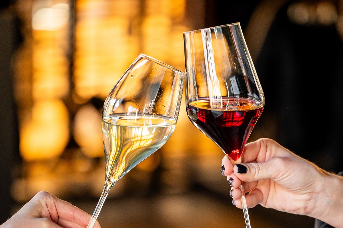 Two,Wine,Glasses,Are,Clinking,In,A,Celebratory,Toast,,One