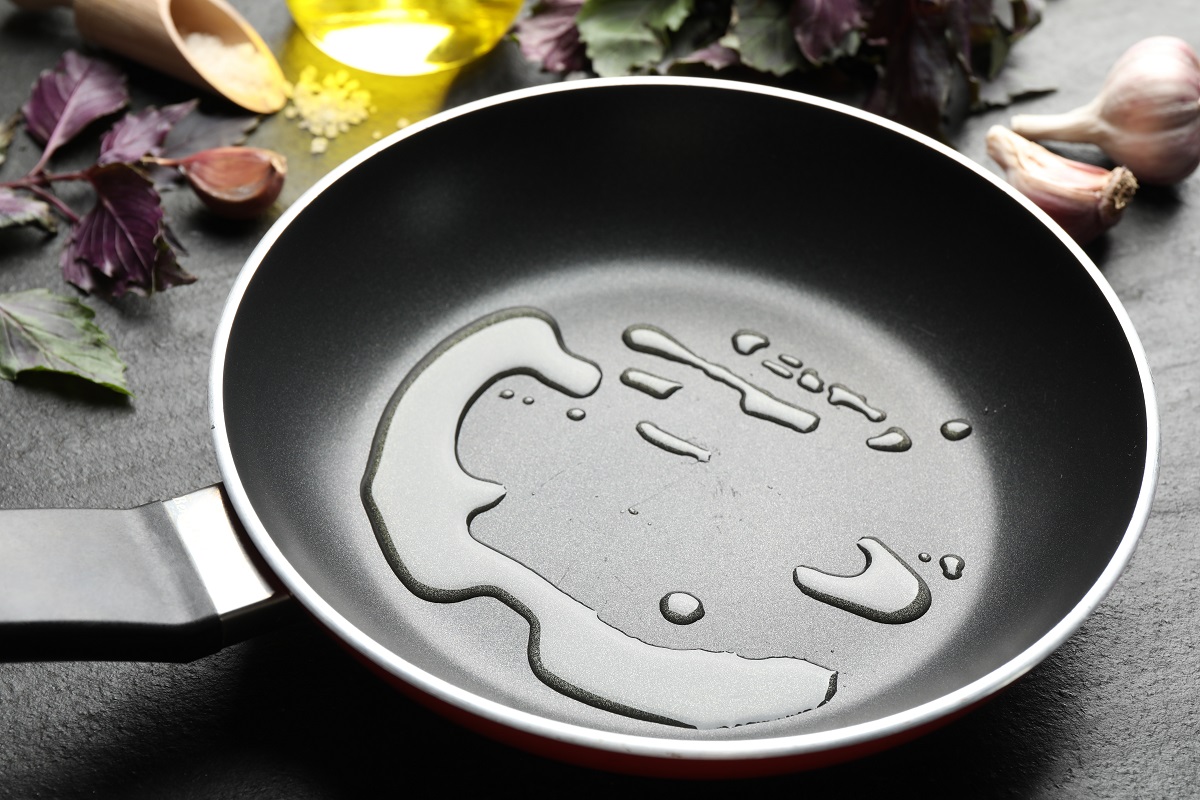 Frying,Pan,With,Cooking,Oil,On,Dark,Table,,Closeup