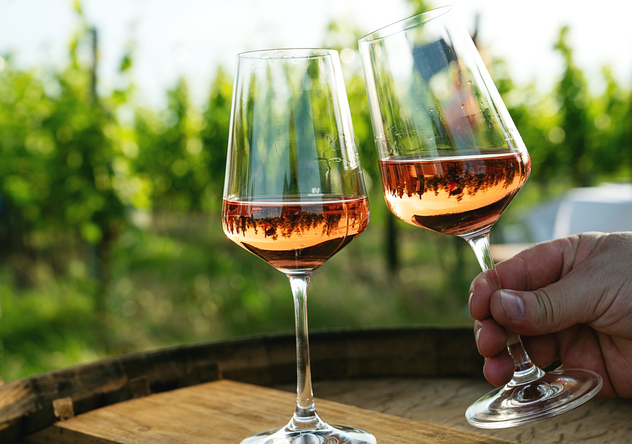 Elegant,Glasses,Of,Rosé,Wine,Against,Vineyard,Scenery,,Capturing,Reflections