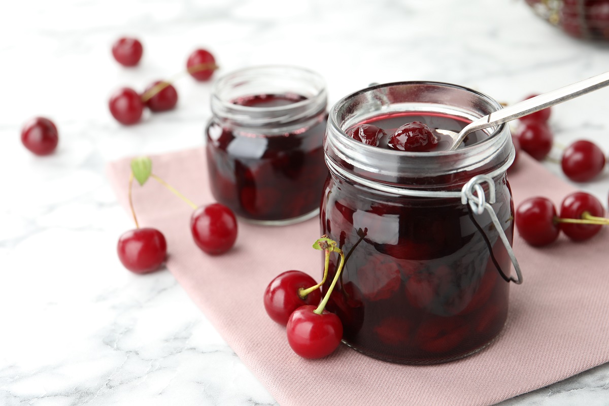 Jars,Of,Pickled,Cherries,And,Fresh,Fruits,On,White,Marble