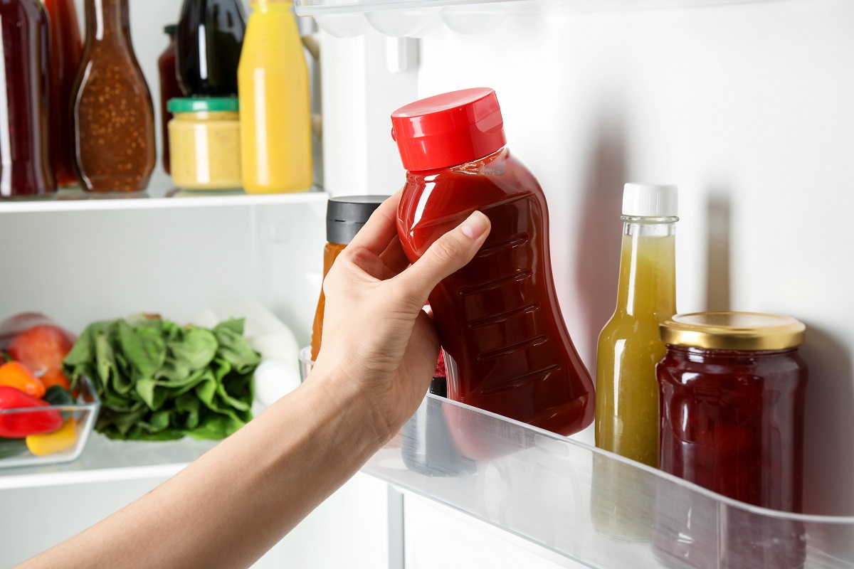 Woman,Taking,Bottle,Of,Tasty,Tomato,Sauce,From,Fridge,,Closeup