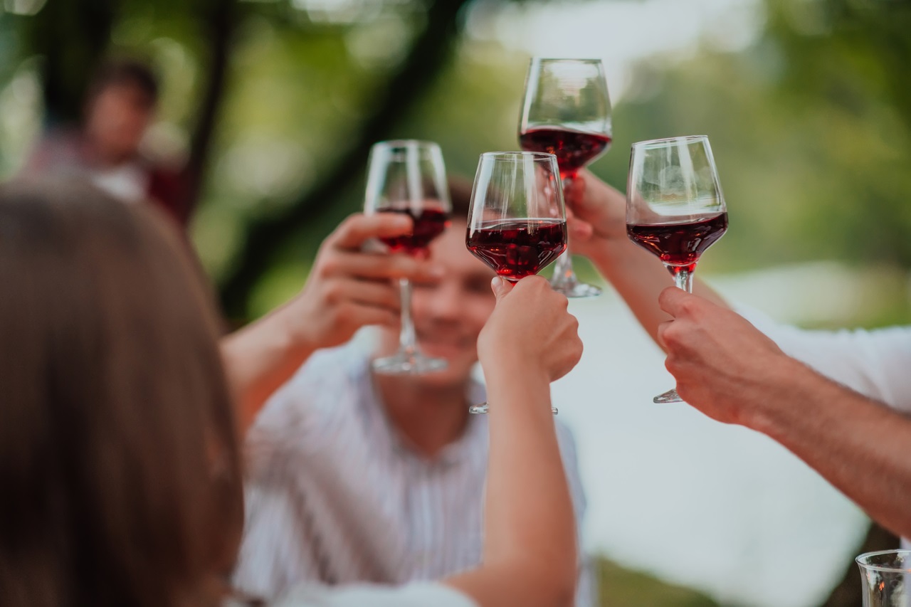 Group,Of,Happy,Friends,Toasting,Red,Wine,Glass,While,Having
