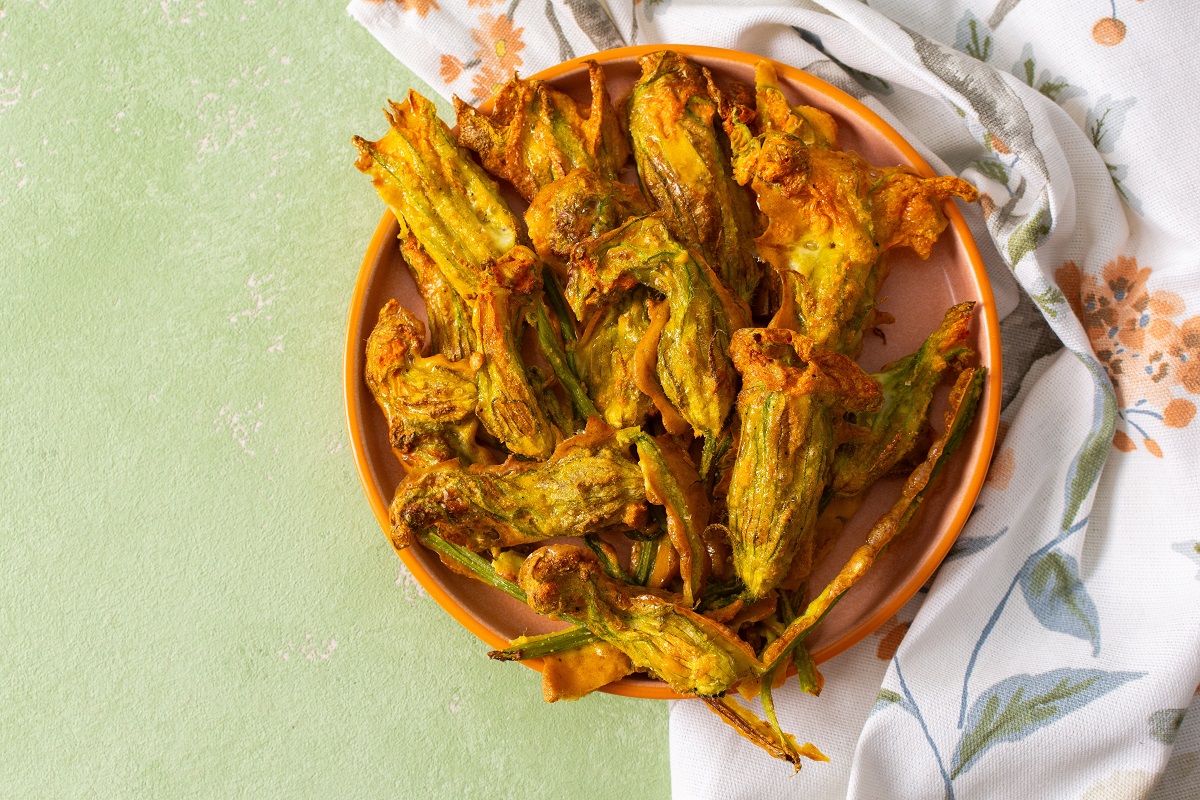 Golden-brown,Deep-fried,Zucchini,Flowers,Are,Arranged,On,A,Vibrant,Plate.