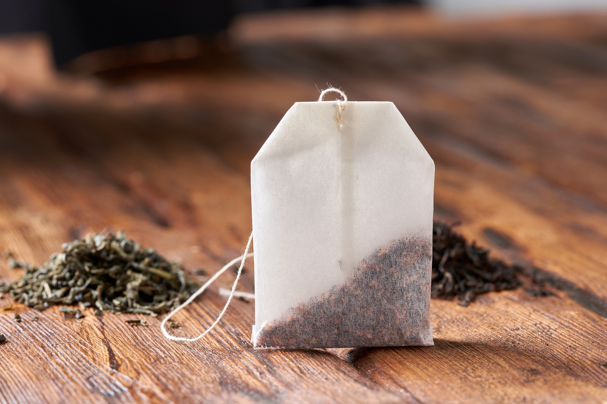 Tea,Bag,,Green,And,Black,Tea,On,An,Old,Wooden