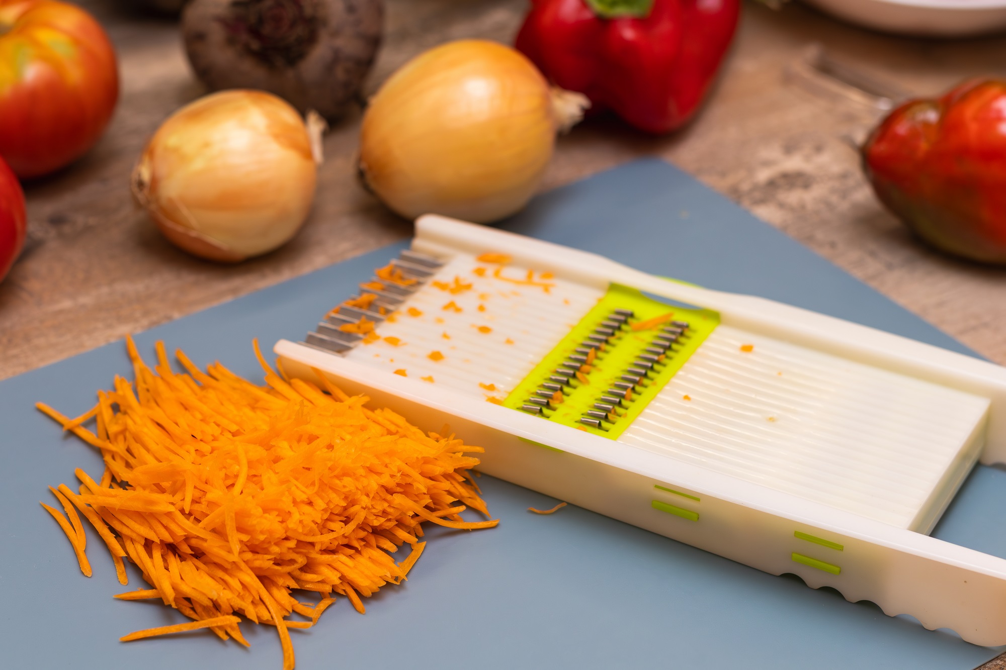 Shredded,Carrots,On,A,Blue,Cutting,Board,Next,To,A